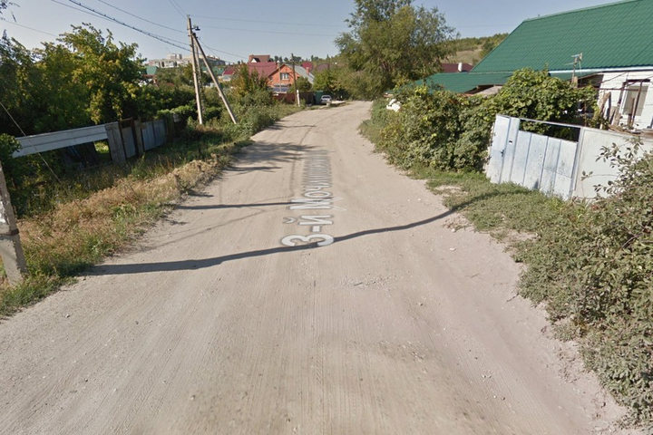 3-й Мочиновский проезд в поселке Рейник (дорога может и проходит по документам, как асфальтовая, но по факту то, что там осталось от покрытия, трудно назвать асфальтом) / © Google Maps