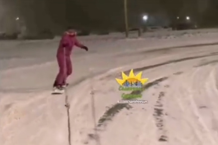 Снежный коллапс. В Солнечном горожанка прокатилась по дороге на сноуборде, прицепившись тросом к авто (видео)