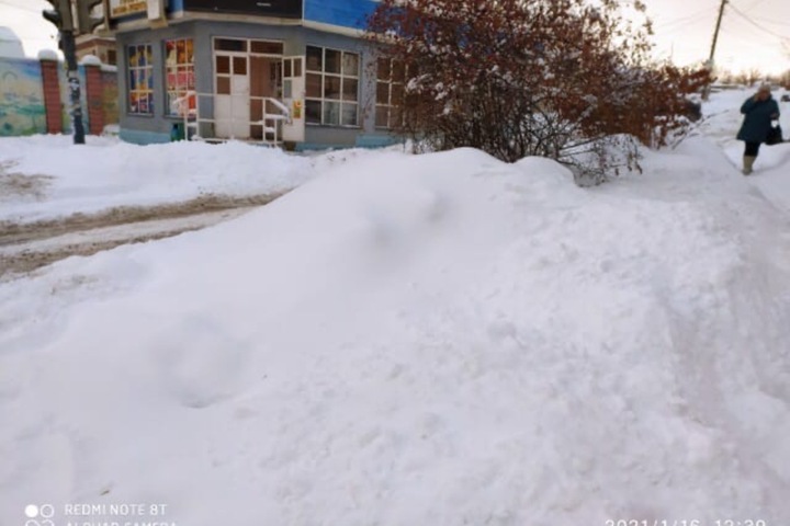 Горожанин о расчистке снега на Соколовой: «С дороги убрали на тротуар, а что не поместилось — спрятали за кустарником»