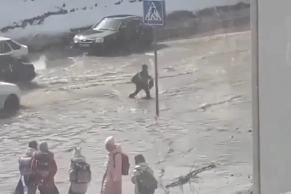 В Ленинском районе недалеко от школы затопило дорогу: дети переходят ее по колено в воде (видео)